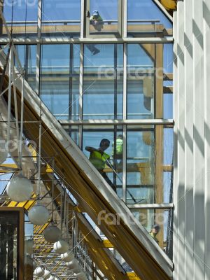 Workers wash a glass wall