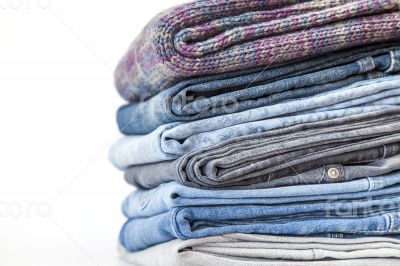 Pile of jeans of various colors on a counter in shop