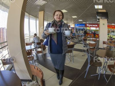 The woman bears two cups of coffee