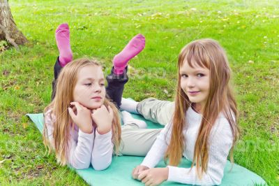 Two girls sitting on grass