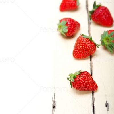 fresh organic strawberry over white wood