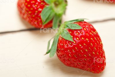 fresh organic strawberry over white wood