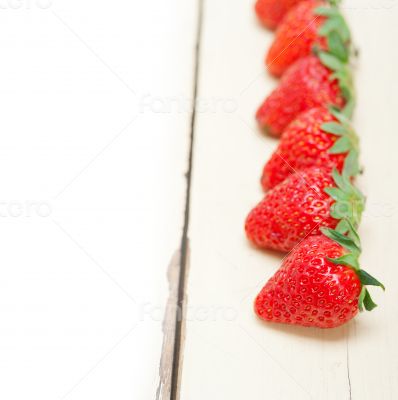fresh organic strawberry over white wood