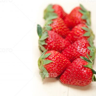 fresh organic strawberry over white wood