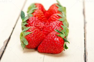 fresh organic strawberry over white wood