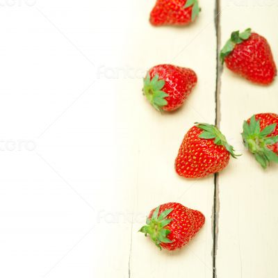 fresh organic strawberry over white wood
