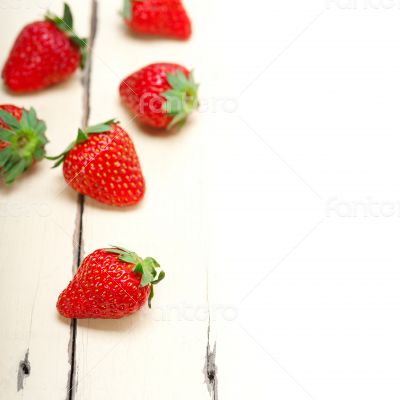 fresh organic strawberry over white wood