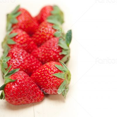 fresh organic strawberry over white wood