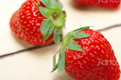 fresh organic strawberry over white wood