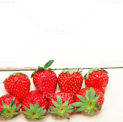 fresh organic strawberry over white wood