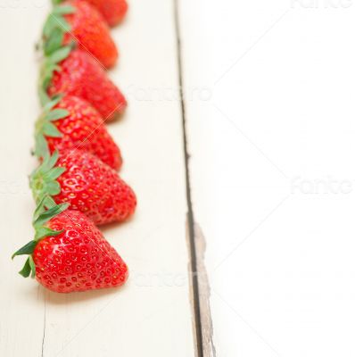 fresh organic strawberry over white wood