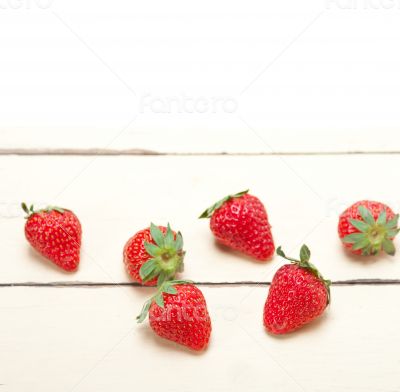 fresh organic strawberry over white wood