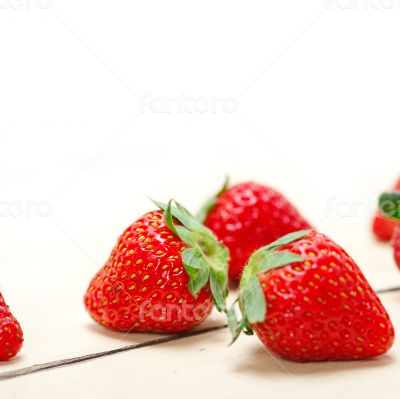 fresh organic strawberry over white wood