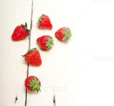 fresh organic strawberry over white wood