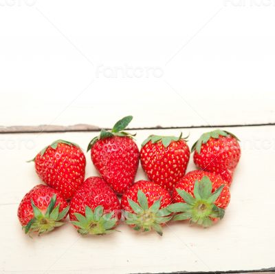 fresh organic strawberry over white wood