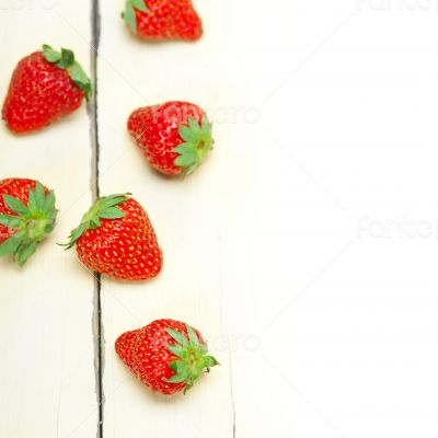 fresh organic strawberry over white wood