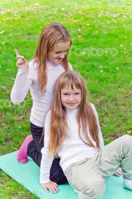 Two girls sitting on grass