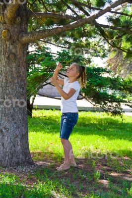 Girl in summer try to jump on tree
