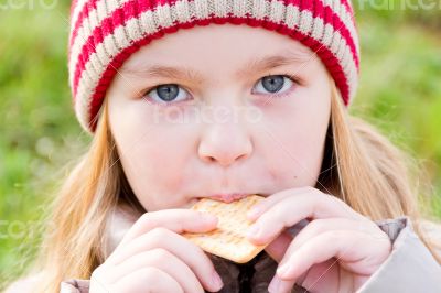 Girl in autumn eating cookie
