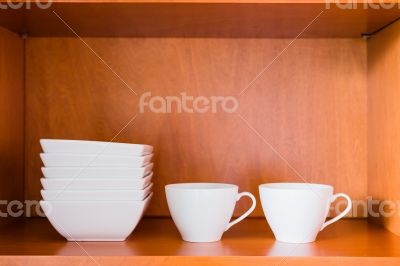 Organized minimalistic kitchen cabinet with white porcelain bowl