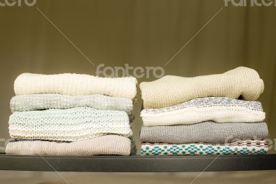 Pile of warm sweaters on a shelf