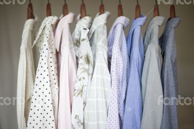 Assorted business shirts on hangers in a closet