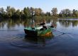 Boy in boat with oars on still river