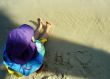 Young child sitting on the sand at the beach
