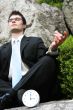 Businessman meditating outside.