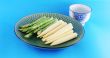 Fresh asparagus shoots and corn on a plate