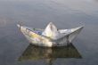 a paper boat floating in a lake