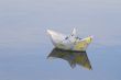 a paper boat floating in a lake