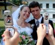 Happy newlyweds posing for cameraphones