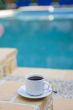cup coffee on background of the pool