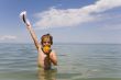 The boy with an orange on a background of the sea