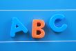 colorful letters A B C on blue board close-ups