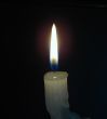 Alone candle flame upon black background