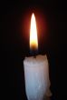 Alone candle flame upon black background