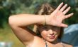 A girl is closed a hand from the rays of a sun