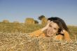Beautiful woman in a field with hay bales