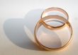 Two wedding gold rings on white background