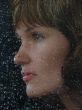 Girl looks thru waterdropped widow glass