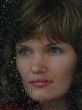 Girl looks thru waterdropped widow glass