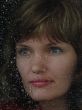 Girl looks thru waterdropped widow glass