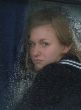 Girl looks thru waterdropped widow glass