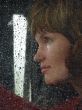 Girl looks thru waterdropped widow glass