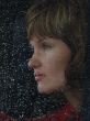 Girl looks thru waterdropped widow glass