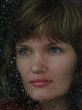 Girl looks thru waterdropped widow glass