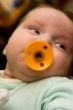 The small baby with a dummy in a mouth
