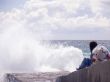 The girl sits on a coast and looks at the sea